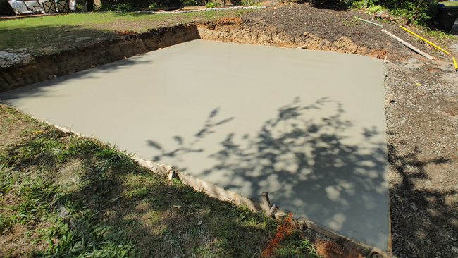 JT Contracting Concrete work - Concrete driveway and parking area with walkway to patio