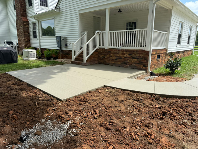 JT Contracting Concrete work - Concrete driveway and parking area with walkway to patio
