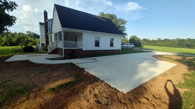 JT Contracting Concrete work - Concrete driveway and parking area with walkway to patio