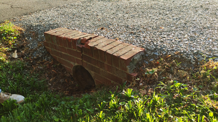 Damaged brick culvert wall needing repair